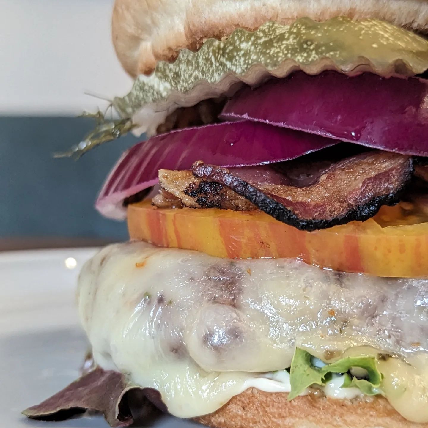 I will never get tired of bacon cheeseburgersThis burger hit the spot and I will make another one similar to this again later this week because it was so good! Pickles, onions, heirloom tomato, lots of cheese, of course bacon, a bit of chopped spring mix lettuce, mayo and mustard and of course a 1/3lb burger. I went with an @oroweatbread keto friendly bun this time. Grilled outside over @bearmountainbbq oak pellets, bacon cooking over the burger.#burger #grilling #bbq #bearmountainbbq #baconcheeseburger #hamburger #foodie #sandiegofood
