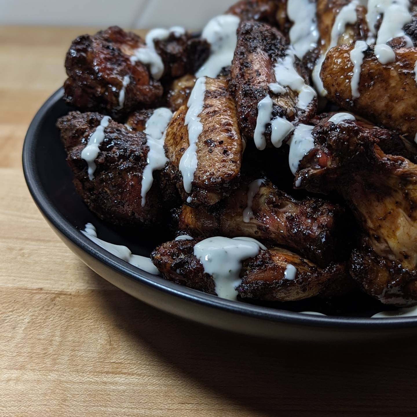 Buffalo & Sriracha Chicken WingsThese smoked chicken wings were just the right level of spicy. I smoked the wings using @bearmountainbbq hickory pellets, setting the smoker to 225 and cook the wings to an internal temp of 165 before upping the heat to crisp them up. 375 for about 10 minutes+the time to climb to temp did the job. The wings were seasoned with @whitebullsbbq bird gang, and when they came of the smoker tossed in equal parts @underwoodranches siracha and @primalkitchenfoods buffalo sauces. With about a tablespoon not butter as well. To serve they were drizzled with @litehousefoods home style each. #chickebwings #buffalochicken #buffalowings #siracha #hotwings #bearmountainbbq #smokedwings #smokedchicken #wingwednesday