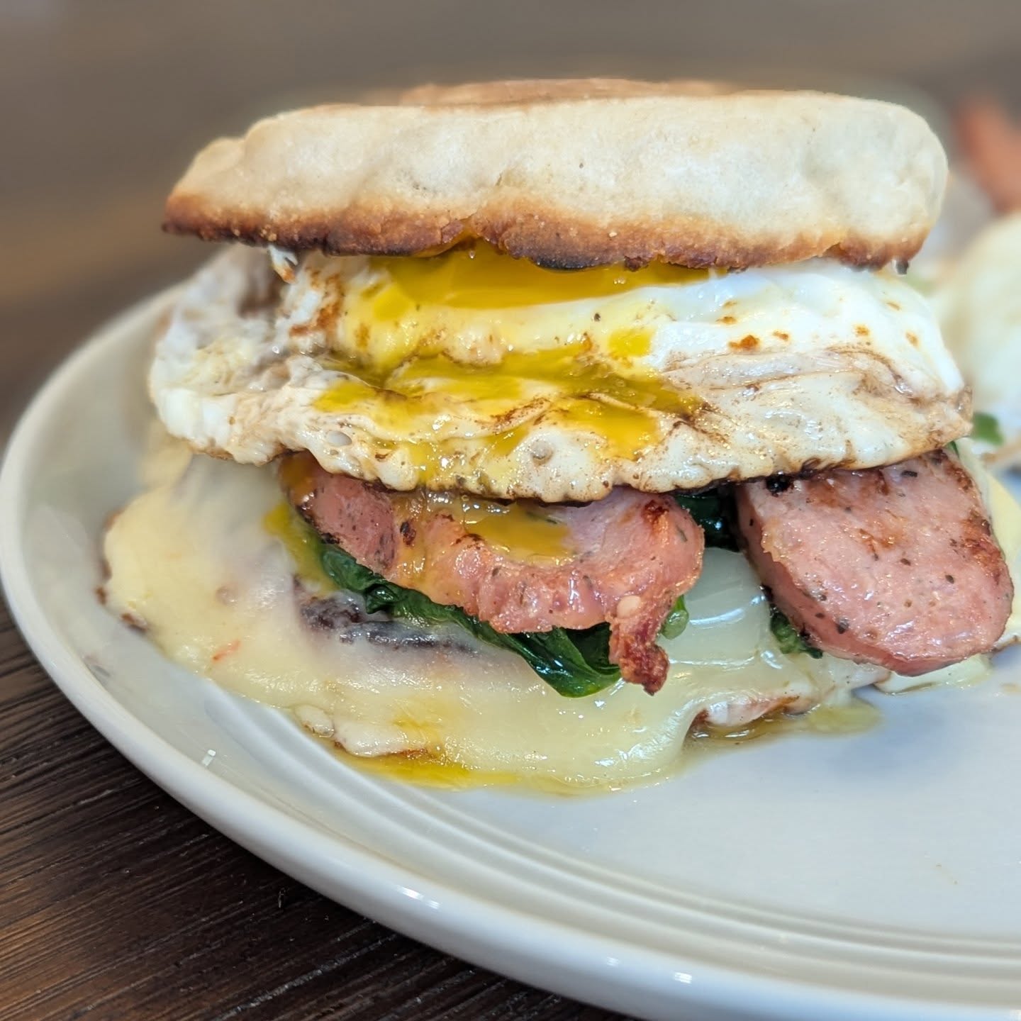 Upgraded take on a Sausage egg and cheese muffin One English muffin loaded with two slices of @cabotcreamery pepper jack cheese, sauteed spinach, a chicken sausage sliced lengthwise, aNd a fried egg. Served with an extra egg and side of bacon. Tons of flavor, plenty of protein and just enough carbs to fuel my morning walk. Have a great Saturday everyone! #breakfastsandwich #brunch #breakfast #cabotcheese #sausageeggandcheese
