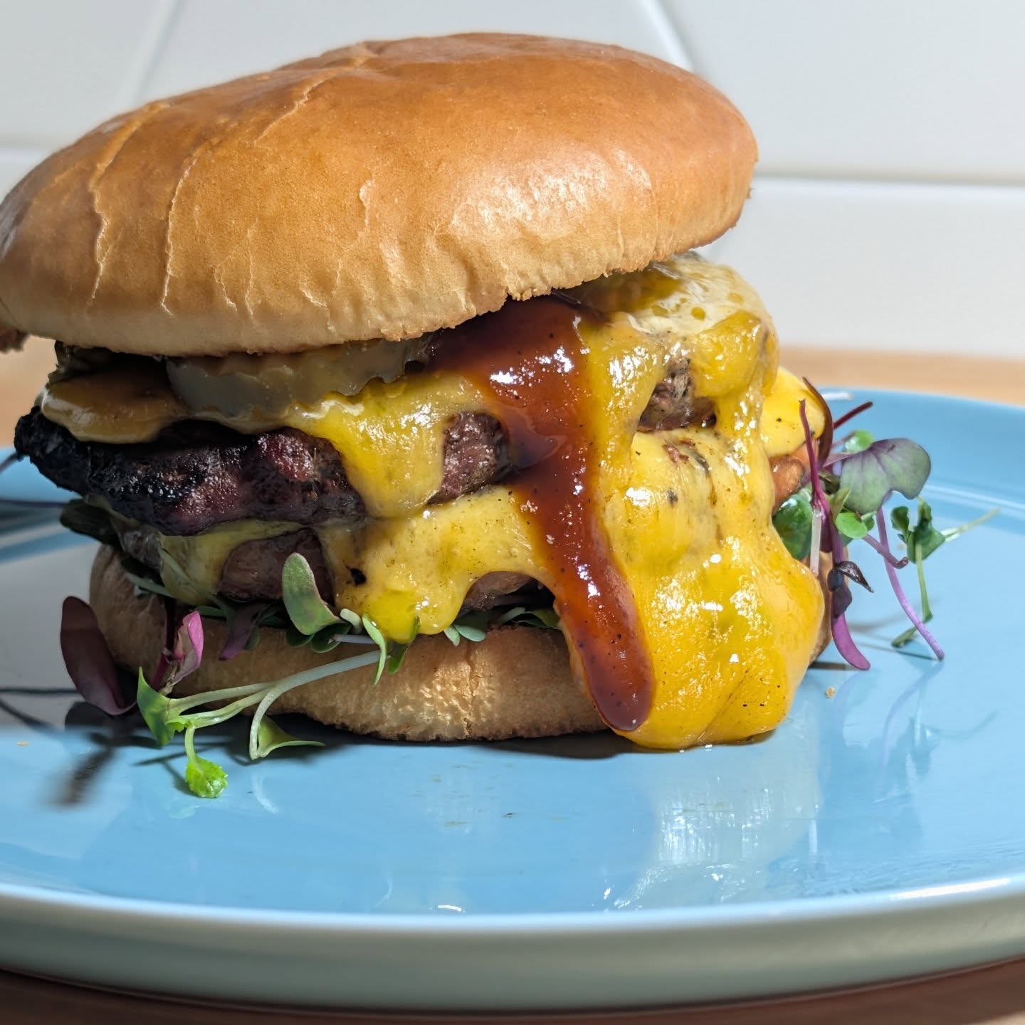 Burger nights are always a winner. I went with one beef patty and one @amylufoods white cheddar & jalapeno patty. Loads of @tillamook cheddar, some @kindersflavors BBQ sauce, @grillospickles  and micro greens. I cooked over a direct flame with @bearmountainbbq old fashioned blend pellets and tested out this new @thechefspress I got as a Christmas gift. #bearmountianbbq #cheeseburger