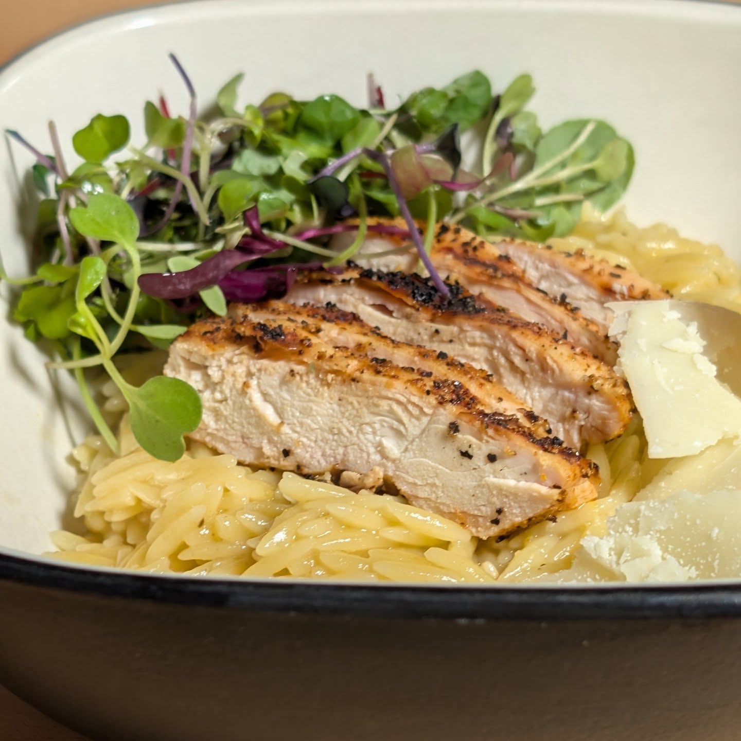 Grilled chicken over lemon orzo with Parmesan and micro greens. I seasoned the chicken with @spiceology buffalo lemon pepper and grilled it over @bearmountainbbq red white and blue blend pellets for that perfect wood fired flavor. This blend burns super efficiently and provides amazing flavor even at higher grilling temps. The orzo cooked with chicken bone broth, lemon juice and lemon zest, seasoned with @spiceology Greek freak. I added Parmesan for a bit of cheese salty punch, and micro greens round of that umami flavor. The first photo is a beautiful shot of the dish, but I needed more protein so scroll to see the bowl with another chicken breast. #bearmountianbbq #chickendinner