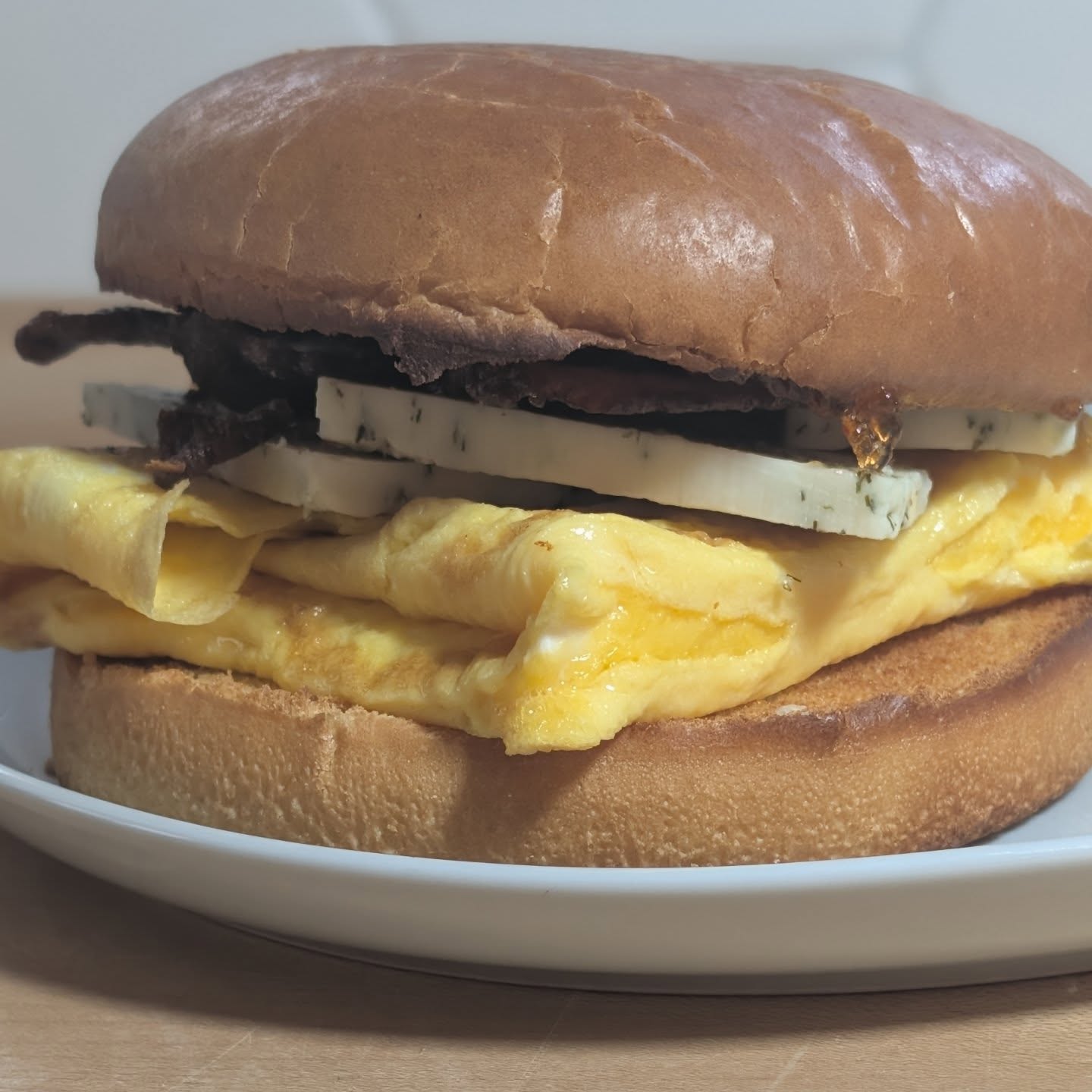 Bacon, Egg and Cheese. But not just any cheese! @cabotcreamery garlic herb cheddar really set this breakfast apart! The bacon is home cured as well, and just so good. Not really visible, but delicious is @tabasco chipotle raspberry jelly. Two eggs, two strips of bacon, some cheese, jelly and a brioche bun to start the day. Now time to go get those steps in!