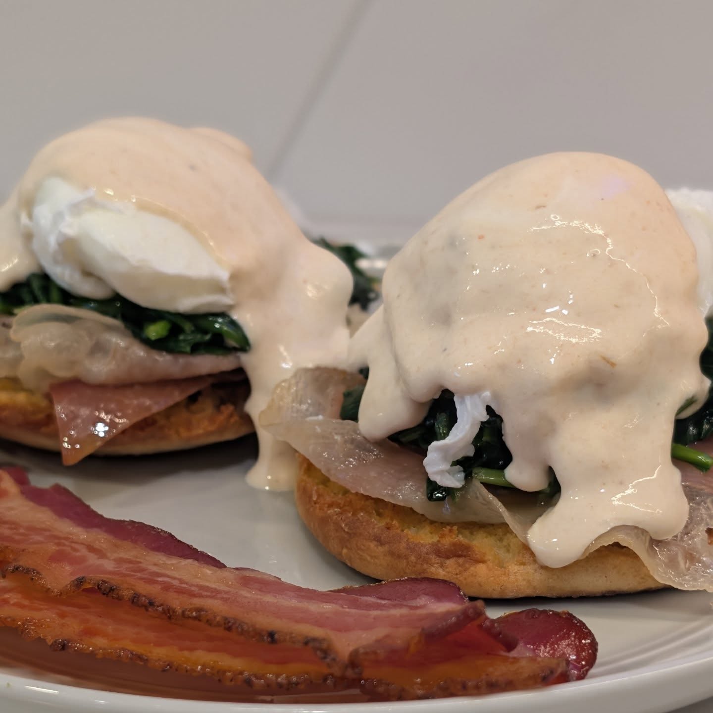 Sunday Benedict English muffin, prosciutto, spinach, poached egg and a sauce that looks like but is not hollandaise. I used some sour cream and hot sauce instead of hollandaise to  avoid the high volume of butter. Served up with a side of my home cured bacon. #benedict #brunch #sundaybrunch
