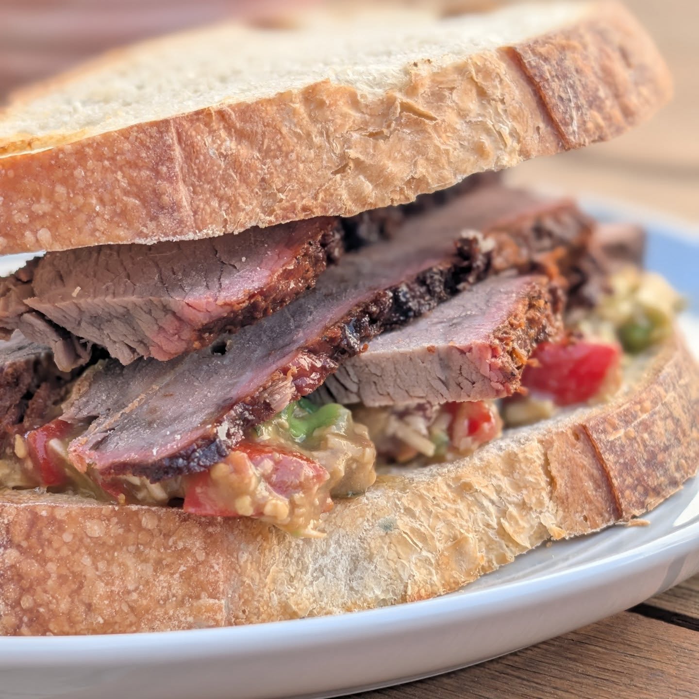 Tri Tip Brisket style sandwich with California Bruschetta I did a low and slow long smoke with @bearmountainbbq gourmet blend on this tri tip. The tri tip was marinated for 2 days in @pepperexchange cayenne mustard and then coated in @spiceology black and blue seasoning. The bruschetta was a mix of fresh tomatoes, garlic, basil, pecorino romano, balsamic and smoked salt. Then to make it California, I added some cubed avocado. Loaded up on some Toasted homemade sourdough bread! The smoke from the gourmet blend did some magic to this tri tip. Giving it a rich but sweet smokey flavor to offset the spice from the mustard. It played really well into the black and blue seasoning. Then by adding a smoked salt to the bruschetta, everything came together so nicely. #bearmountianbbq #bruschetta #steaksandwich