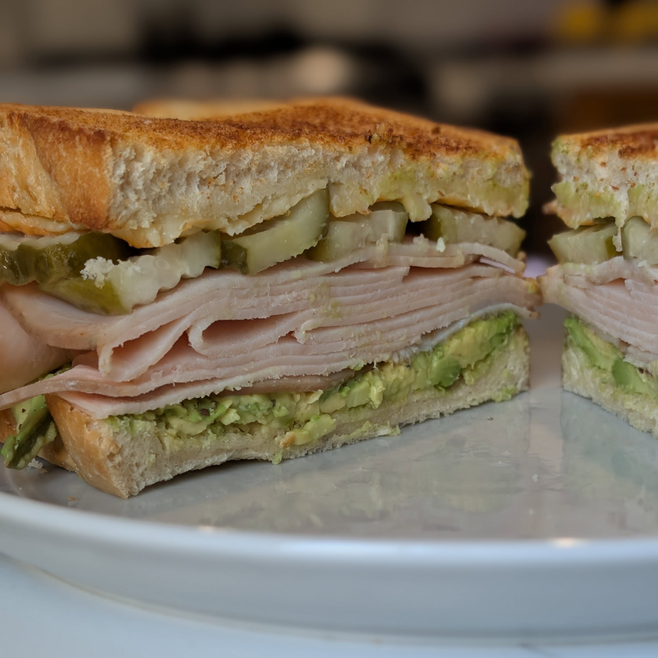 A turkey sandwich just hits the spot. Toasted sourdough (store bought this item) with a half an avocado on one side and @cabotcreamery horseradish cheddar on the other. I give the avocado a sprinkle of salt and pepper and then plenty of sliced turkey and @grillospickles to finish it off. The salt and pepper on the avocado add flavor but also help keep that turkey from sliding around. #sandwich #cabotcheese #turkeysandwich